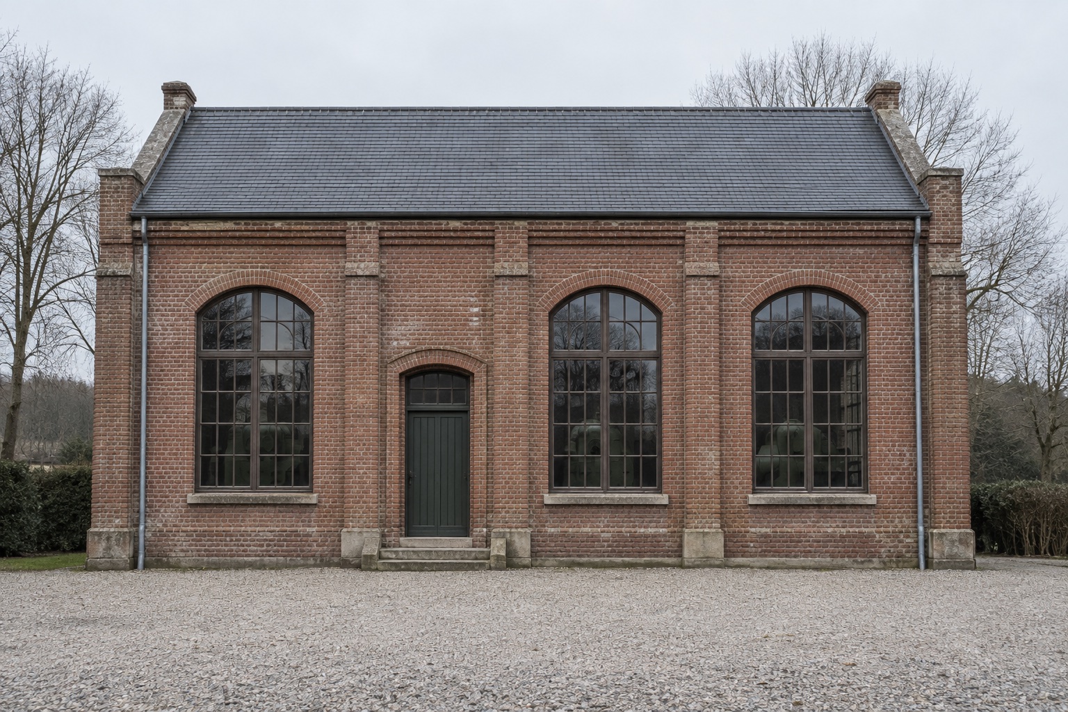 Wellgate Pump House, a brick engine hall with three tall arched windows, photographed square on.