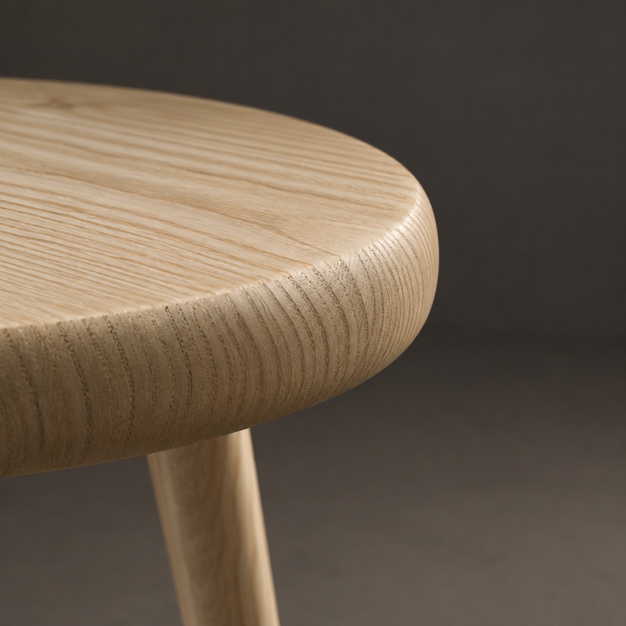 The seat's rounded edge seen almost side on, with the end grain running round it under a matte oil.